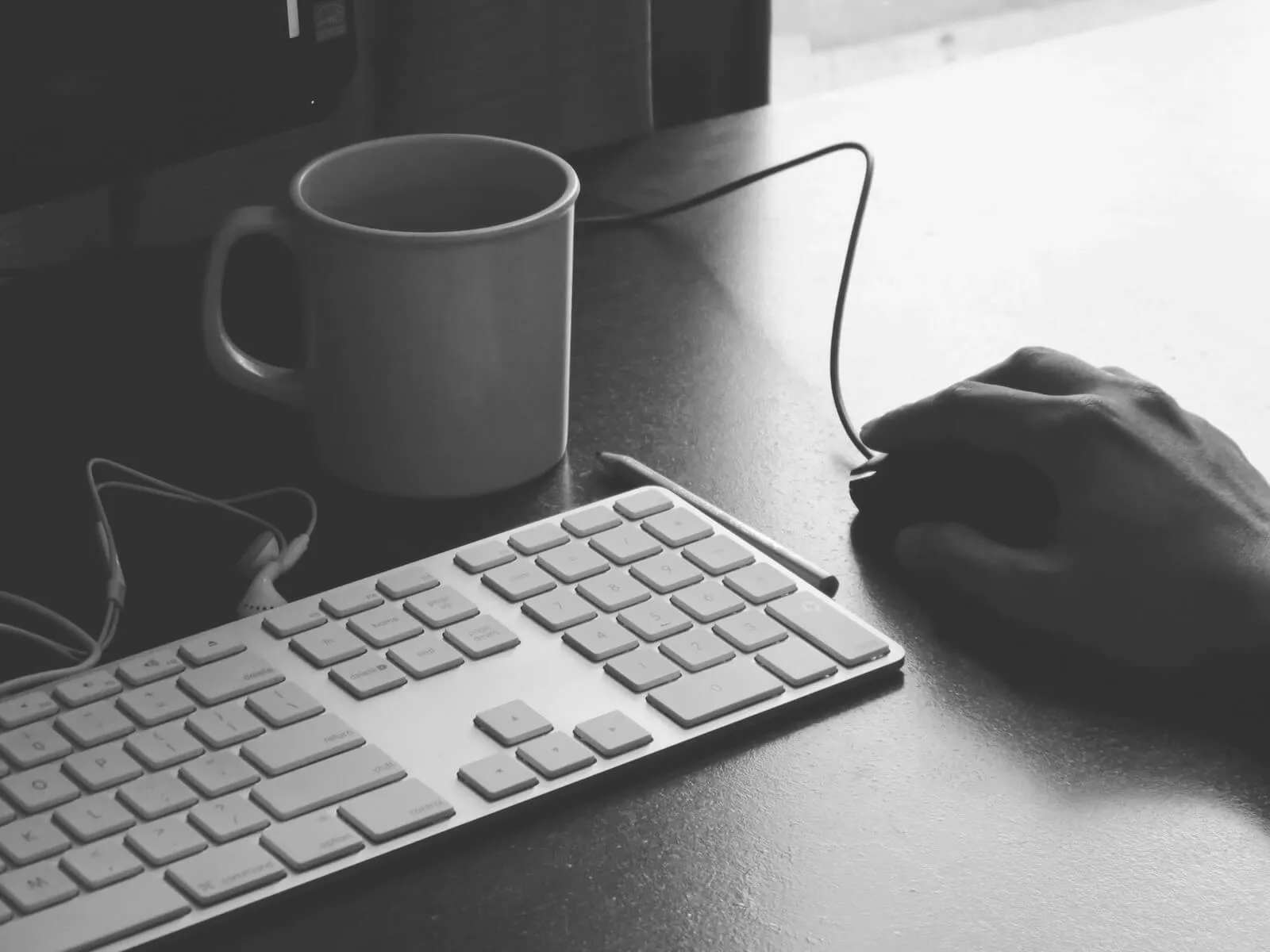 Keyboard and coffee mug on a desk